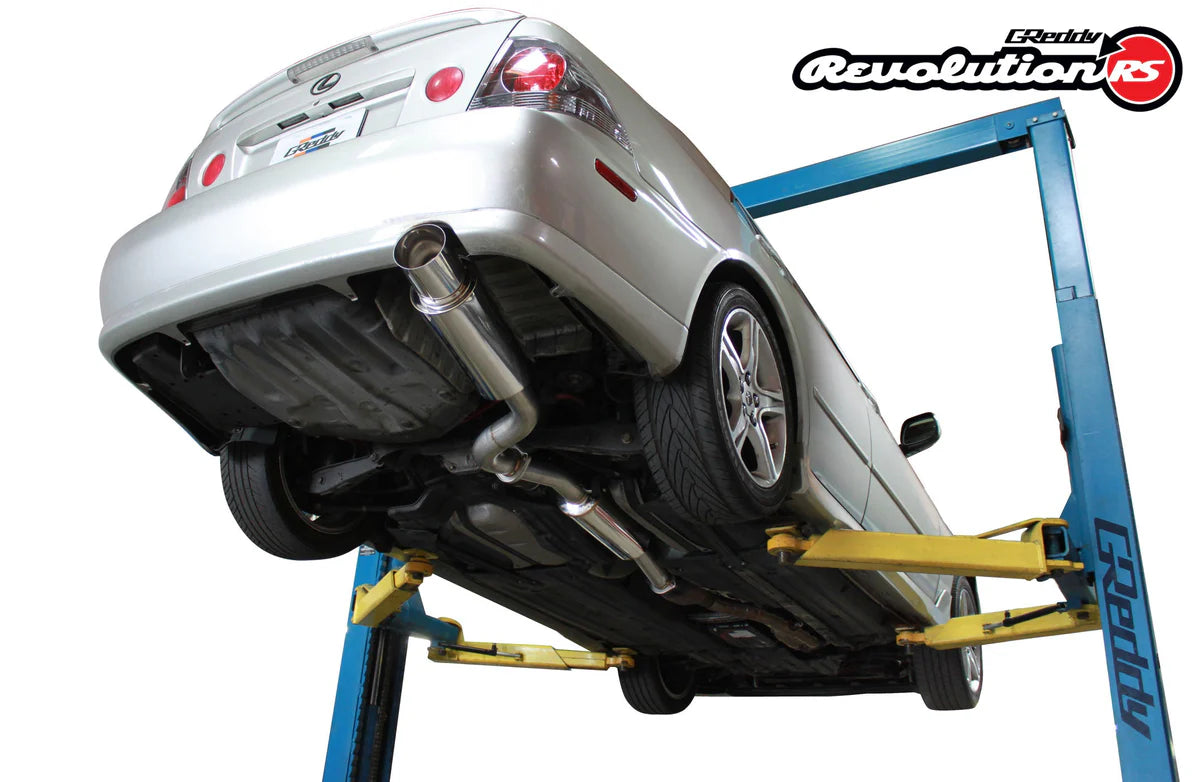 Underside view of a Lexus IS300 showing the GReddy Revolution RS 3-inch catback exhaust system with its high-flow straight-through piping layout