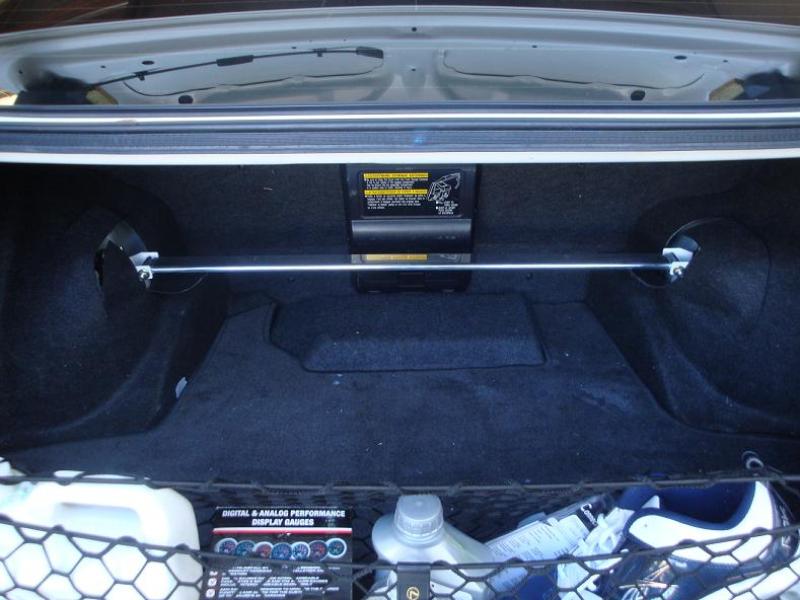 View inside a Lexus IS300 trunk showing the installed Megan Racing Race-Spec rear strut tower bar bridging the shock towers