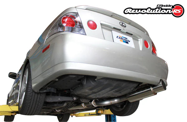 Low-angle shot of the GReddy Revolution RS V2 on an IS300, showcasing the high-mirror polish of the 304 stainless steel canister