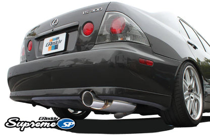 Rear view of a Lexus IS300 featuring the GReddy Supreme SP catback exhaust, showing the signature oval muffler and polished tip