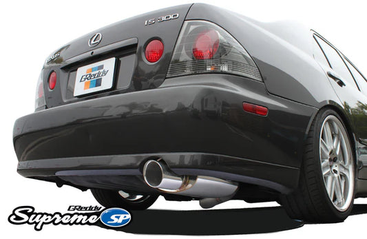 Rear view of a Lexus IS300 featuring the GReddy Supreme SP catback exhaust, showing the signature oval muffler and polished tip