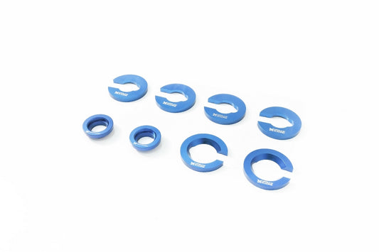 Eight-piece Megan Racing rear subframe bushing collar kit for 2001-2005 Lexus IS300, CNC-machined from aluminum with a blue finish
