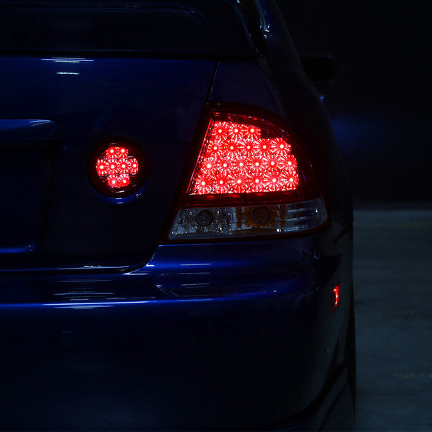 Spec-D LED tail lights with chrome housing and red clear lens installed on car illuminated showing LED running and brake light patterns at night